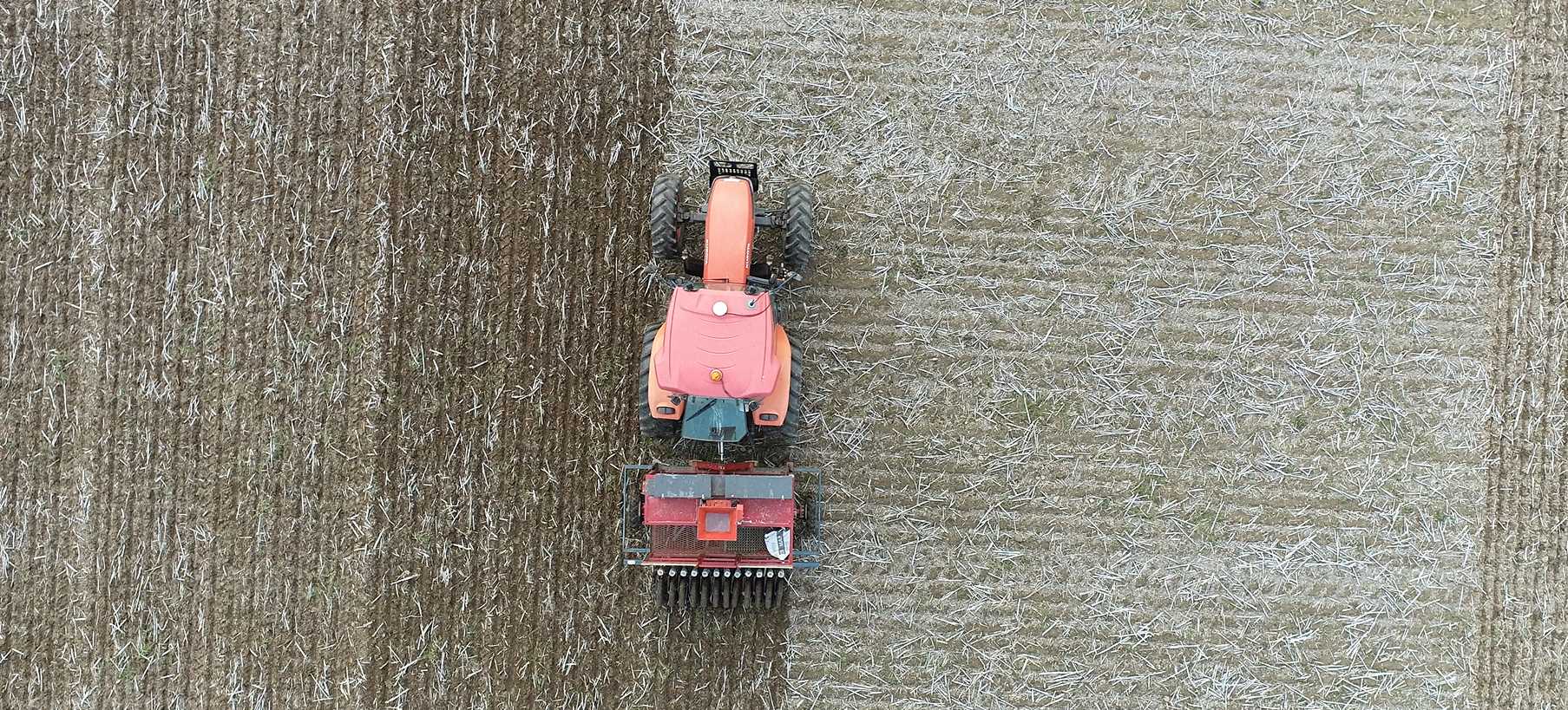 Drone shot of tractor sowing seed in a test plot